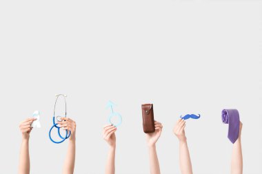 Açık mavi kurdeleli kadın eller, steteskop, erkek işareti, beyaz arka planda bıyık ve kravat. Prostat kanseri kavramı