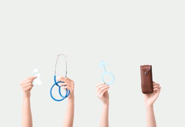 Açık mavi kurdeleli kadın eller, steteskop, beyaz arka planda erkek işareti ve gözlük kutusu. Prostat kanseri kavramı