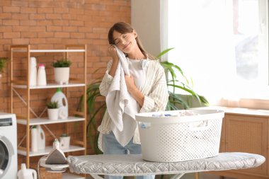 Çamaşır odasında temiz havlusu olan genç bir kadın.