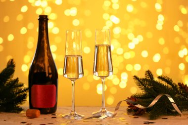 Bulanık ışıklara karşı bir şişe şampanya ve Noel süsü.