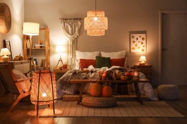 Sonbahar süslemeleri ve akşamları mumları olan şık bir yatak odası.