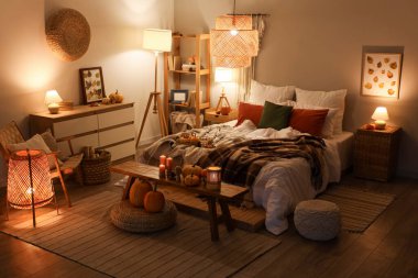 Sonbahar süslemeleri ve akşamları mumları olan şık bir yatak odası.