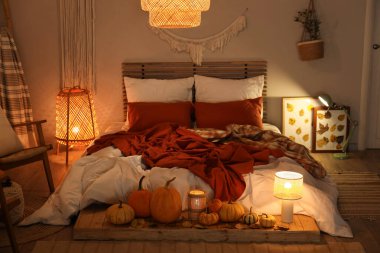 Sonbahar süslemeleri ve akşamları mumları olan şık bir yatak odası.