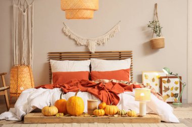 Sonbahar süslemeleri ve büyük yataklı şık bir yatak odası.