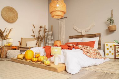 Sonbahar süslemeleri ve büyük yataklı şık bir yatak odası.