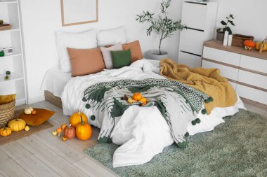 Çekmeceler ve balkabaklarıyla aydınlık yatak odasının içinde.