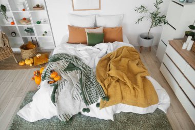 Raflar, çekmeceler ve balkabaklarıyla aydınlık yatak odasının içinde.