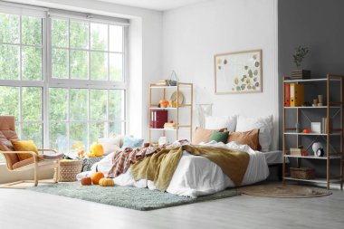 Yatak odasının içinde raf üniteleri ve balkabakları var.