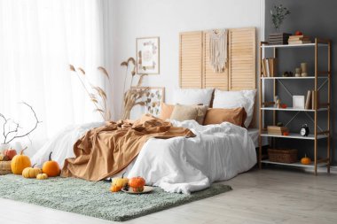 Yatak odasının içinde raf ünitesi, otlar ve balkabakları var.