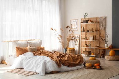 Yatak odasının içinde raf ünitesi, otlar ve balkabakları var.