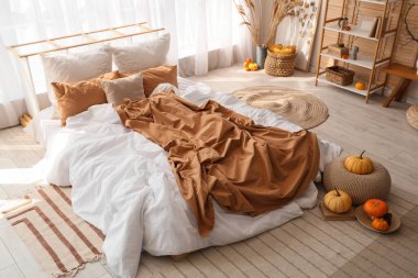 Yatak odasının içinde raf ünitesi, otlar ve balkabakları var.