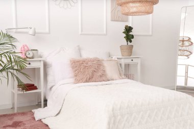 Rahat yataklı, komodinli ve aynalı ergen yatak odasının içi.