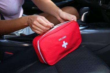 Arabada ilk yardım çantası olan bir sürücü.