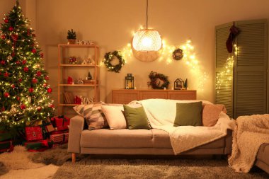Gri kanepe, Noel ağacı ve akşamları parlayan ışıklarla dolu bir oturma odası.