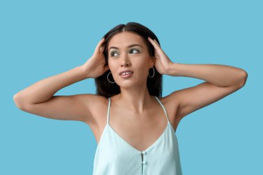 Mavi arka planda zarif nane makyajlı güzel bir Asyalı kadın.