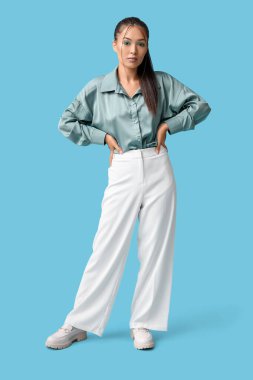 Mavi arka planda zarif nane makyajlı güzel bir Asyalı kadın.