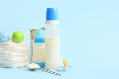 Bebek sütü formülü, bebek bezi, çıngırak ve emzik içeren şişeler