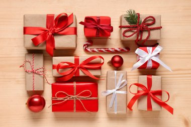 Noel hediye kutularında köknar ağacı dalı ve ahşap arka planda dekor var.