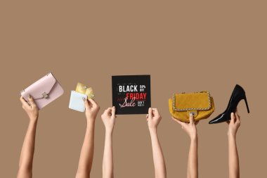 Bej arka planda kredi kartları ve aksesuarları olan eller. Kara Cuma indirimi