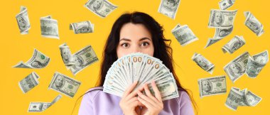 Sarı arka planda parası olan güzel bir genç kadın.