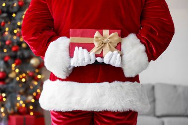 Noel arifesinde evde hediye kutusuyla Noel Baba, arka manzara