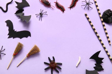 Frame made from Halloween candy bugs, bats and brooms on lilac background clipart