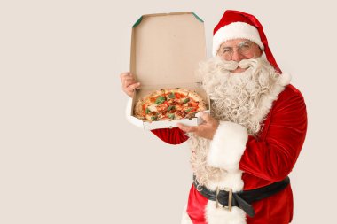 Beyaz arka planda bir kutu lezzetli pizza olan Noel Baba.