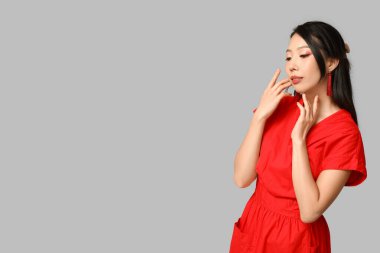 Gri arka planda güzel bir Asyalı kadın. Çin Yeni Yıl Kutlaması