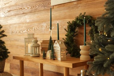 Kitaplar, fenerler, yanan mumlar ve evdeki ahşap bankta Noel dekoru, yakın çekim.