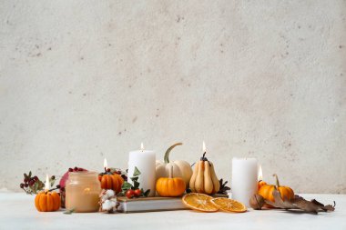 Beyaz arka planda yanan mumlar, gül kalçası böğürtlenleri, ceviz ve kurutulmuş turuncu