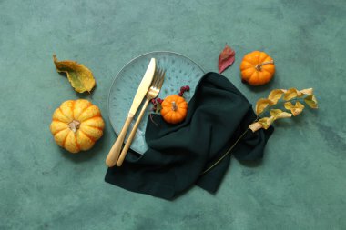 Taze balkabakları, gül kalçası böğürtlenleri ve yeşil arka planda sonbahar yapraklarıyla güzel bir masa.