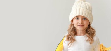 Kış giysileri içinde güzel bir kız. Arka planda açık renk. Mesaj için yeri var.