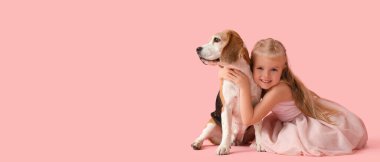 Tatlı küçük kız ve pembe arka planda Beagle köpeği mesaj atmak için yer var.
