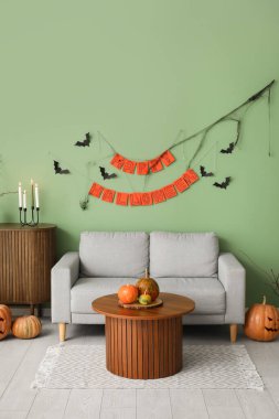 Cadılar Bayramı için kanepe ve balkabaklarıyla dekore edilmiş oturma odasının içi.