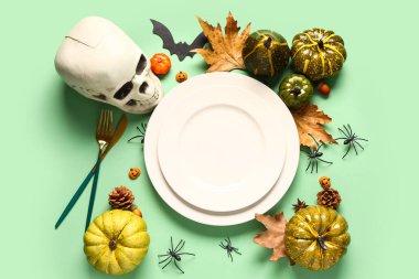 Kafatası ve yeşil arka planda sonbahar dekoru olan Cadılar Bayramı sofrası