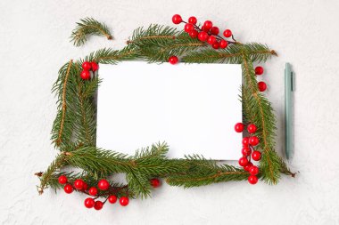 Beyaz arka planda köknar dalları ve viburum olan boş Noel kartı