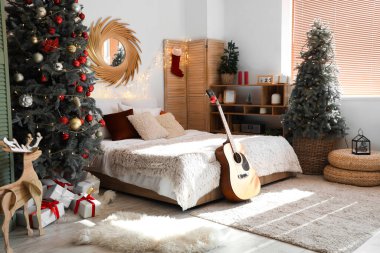 Noel odasının içi süslenmiş köknar ağaçları ve gitarlarla dolu.