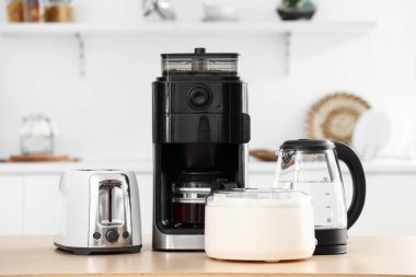 Hafif mutfakta modern aletler bulunan ahşap masa.