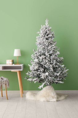 Güzel Noel ağacı ve yeşil duvarın yanındaki masa