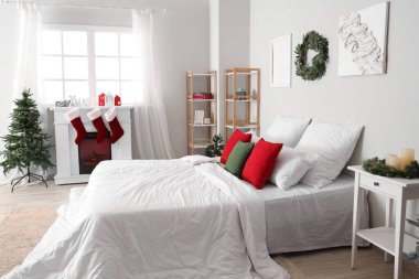 Noel ağacı ve şöminesi olan aydınlık yatak odasının içinde.