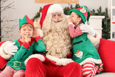 Noel arifesinde Noel Baba 'nın yanında küçük elfler.