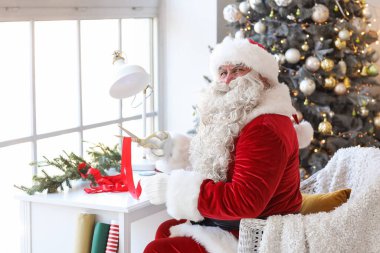 Noel Baba evde Noel hediyesi yapıyor.