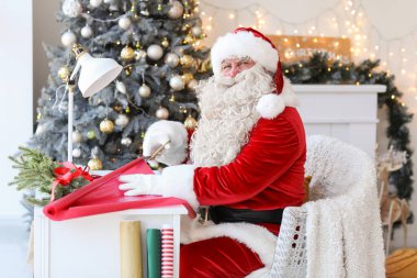 Noel Baba evde Noel hediyesi yapıyor.