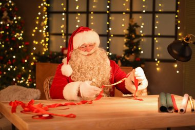 Noel Baba evde Noel hediyesi yapıyor.