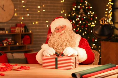 Noel Baba evde Noel hediyesi yapıyor.