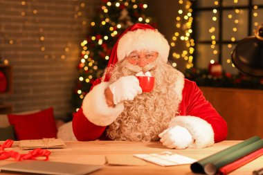 Noel Baba, Noel arifesinde evde lokumla sıcak çikolata içiyor.