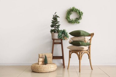 Evin içi dekoratif yastıklarla, minicik Noel ağacı ve ökseotu çelenkleriyle dolu.