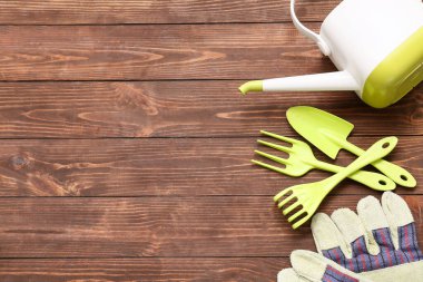 Kahverengi ahşap arka planda bahçe işleri için araçlar. Üst görünüm