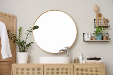 Modern lavabo, çekmeceler ve banyo duvarının yanındaki bitkiler.