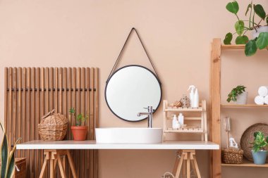 Modern lavabo, masa ve raf, banyonun iç tarafındaki bej duvarın yanında.